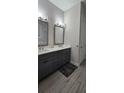 Modern bathroom featuring a double vanity with sleek gray cabinets and wood-look flooring at 3000 Keeneland Blvd, Mcdonough, GA 30252