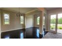Bright, open living room with hardwood floors, elegant chandeliers, and large windows overlooking the outdoors at 3000 Keeneland Blvd, Mcdonough, GA 30252