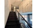 Modern staircase featuring sleek black railings and a view of the home's light-filled, open floor plan at 3000 Keeneland Blvd, Mcdonough, GA 30252