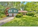 Exterior view showcasing the home's charming facade, lush green lawn, and mature trees creating a serene setting at 316 Shiloh Hills Nw Dr, Kennesaw, GA 30144