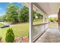 Covered front porch with slate tile flooring, white railings and columns, and landscaping views at 3781 Cherokee Trl, Suwanee, GA 30024