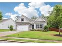 Attractive home with a well-maintained lawn, stone details, and an attached two-car garage at 306 Lark Ln, Canton, GA 30115