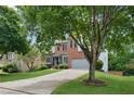 Beautiful brick home with a pristine lawn, mature trees, and convenient two-car garage at 11040 Regal Forest Dr, Johns Creek, GA 30024