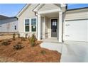 Inviting front entrance highlighting the stylish front door, manicured lawn, and an attached two-car garage at 1783 Juniper Berry Way, Loganville, GA 30052