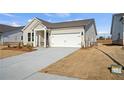 Front exterior showcasing driveway and lawn leading up to the charming, single-story home's two-car garage at 1783 Juniper Berry Way, Loganville, GA 30052