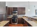 Modern kitchen with granite counters, stainless appliances, and dark wood cabinets and backsplash at 870 Inman Village Ne Pkwy # 229, Atlanta, GA 30307
