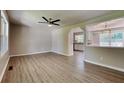 Spacious living room with modern ceiling fan and wood-look flooring, flowing into kitchen area at 11953 Brown Bridge Rd, Covington, GA 30016