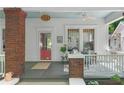 Charming front porch with brick columns, a cozy seating area, and view of the neighborhood at 291 Elmira Ne Pl, Atlanta, GA 30307