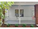 Inviting front porch with a white railing, brick columns, and a porch swing, perfect for relaxing at 291 Elmira Ne Pl, Atlanta, GA 30307