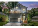 Modern two-story home with gray accent wall, balcony, sleek garage door, and professional landscaping at 2186 Park Terrace, College Park, GA 30337