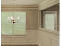 Elegant dining area featuring wainscoting, modern light fixture, and large windows at 2429 Wood Bend Ln, Riverdale, GA 30296