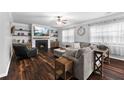 Comfortable Gathering room with a cozy fireplace, built-in shelves, and hardwood floors at 3016 Levinshire Way, Dacula, GA 30019