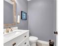 Stylish half bathroom featuring granite counters, vanity with bronze hardware, and a modern toilet at 2102 Braswell Ln, Loganville, GA 30052