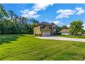 Lovely home with lush green lawn, side-entry garage, and mature trees at 2102 Braswell Ln, Loganville, GA 30052