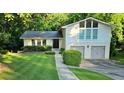Charming two-story home with a well-manicured lawn, beautiful greenery, and a two car garage at 2804 Dunnington Cir, Chamblee, GA 30341