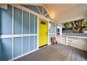 Inviting covered front porch with blue siding, white trim, and a bright yellow door at 106 Adair Ave, Atlanta, GA 30315