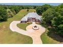Aerial view of a well-maintained home with a circular driveway, manicured lawn, and mature landscaping at 3030 Berry Rd, Loganville, GA 30052