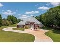 Beautiful brick home with detailed architecture, circular driveway, and meticulously maintained lawn at 3030 Berry Rd, Loganville, GA 30052