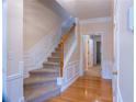Inviting hallway features hardwood floors, staircase, and detailed trim work, leading to other rooms at 5587 Trace Views Dr, Norcross, GA 30071