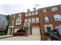 The brick townhouse features a one-car garage, trimmed windows, and well-maintained landscaping at 5587 Trace Views Dr, Norcross, GA 30071