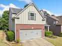 Two-story home featuring a brick facade, attached garage, and well-maintained landscaping at 121 Camdyn Cir, Woodstock, GA 30188