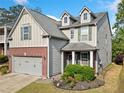 Charming two-story home showcasing manicured landscaping, a gray exterior, and a convenient two-car garage at 121 Camdyn Cir, Woodstock, GA 30188