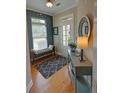 Inviting entryway featuring hardwood floors, a stylish console table, and a cozy bench, bathed in natural light at 2771 Middlecreek Way, Cumming, GA 30041