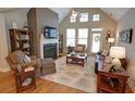 Spacious living room with vaulted ceilings, a cozy fireplace, and large windows offering plenty of natural light at 2771 Middlecreek Way, Cumming, GA 30041