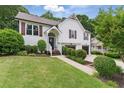 Charming two-story home featuring a welcoming front porch, well-manicured lawn, and a two-car garage at 387 Rose Creek Pl, Woodstock, GA 30189