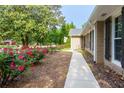 Landscaped walkway leading to the house, lined with vibrant pink roses and mature trees at 690 Glenforest Rd, Sandy Springs, GA 30328