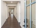 Inviting hallway with dark wood floors leading to the main living area of the home at 3564 Arrow Root Cir, Loganville, GA 30052