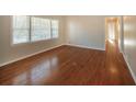 Bright living room featuring gleaming hardwood floors and natural light from large windows at 6575 Wendell Cir, Morrow, GA 30260