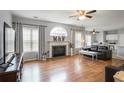 Bright living room featuring fireplace, large window, hardwood floors, and comfortable seating area at 868 Cork Oak Ln, Lawrenceville, GA 30045