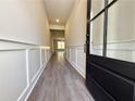 Entrance hallway with gray wood flooring, white wainscoting, leading towards a brightly lit living area at 5706 Urban Village Way # 4, Tucker, GA 30084