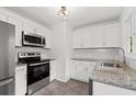 Well-lit kitchen featuring stainless steel appliances, granite countertops, and white cabinetry at 1142 Palafox Ne Dr, Atlanta, GA 30324
