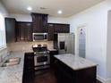 Modern kitchen with dark cabinets, stainless steel appliances, and granite countertops at 2249 Knoxhill Se Vw, Smyrna, GA 30082