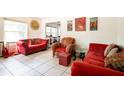 Bright living room with tile floors, large window, and vibrant red sofas and decor at 311 Henry Aaron Ave, Atlanta, GA 30310