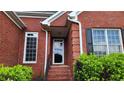 Inviting front entrance with a storm door, brick steps, and manicured shrubs at 3858 Glenlake Dr, Douglasville, GA 30134