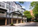 View of an attractive townhouse with a private balcony, stone accents, and a two-car garage at 221 Semel Nw Dr # 273, Atlanta, GA 30309