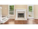 Bright living room featuring a fireplace, hardwood floors, and a large window at 214 Kingsley Way, Woodstock, GA 30188