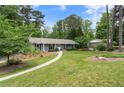 Charming single-story home with gray siding, black shutters, manicured lawn, and mature trees at 3131 Garden Lane Dr, Marietta, GA 30062