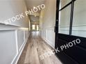 Inviting entryway with board and batten walls and durable laminate flooring leading into the home at 5720 Urban Village Way # 7, Tucker, GA 30084