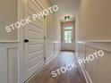 Hallway features board and batten walls and durable laminate flooring at 5720 Urban Village Way # 7, Tucker, GA 30084