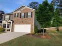 Beautiful house with a well-maintained lawn, a two-car garage, and a mix of brick and siding at 9405 Bandywood Dr, Covington, GA 30014