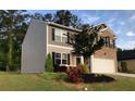 Charming home boasts a manicured lawn, colorful flower beds, and a two-car garage, enhancing its curb appeal at 9405 Bandywood Dr, Covington, GA 30014