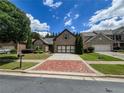 Charming brick home featuring a spacious driveway, a two-car garage, and a beautifully landscaped yard at 2826 Staunton Dr, Duluth, GA 30097