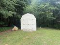 Backyard shed with double doors, concrete steps and green landscaping at 42 Grant Nw Dr, Cartersville, GA 30121