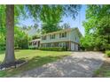 This two-story home has a long driveway and an attached garage, surrounded by mature trees at 4842 Mcpherson Ne Dr, Roswell, GA 30075