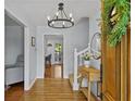 Bright foyer with hardwood floors, modern chandelier, and view of the staircase at 4842 Mcpherson Ne Dr, Roswell, GA 30075