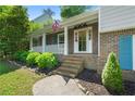 Inviting front porch with brick steps, white railings, and beautiful landscaping at 4842 Mcpherson Ne Dr, Roswell, GA 30075
